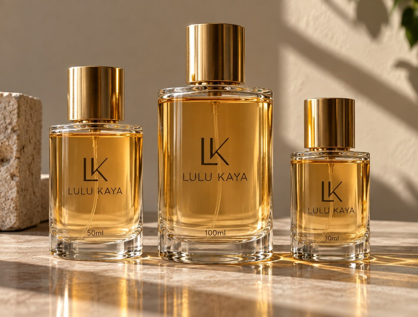 Three Lulu Kaya perfume bottles, 50 ml, 100 ml and 30 ml, with gold caps